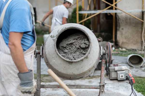 Concrete mixer being used by a worker outdoors